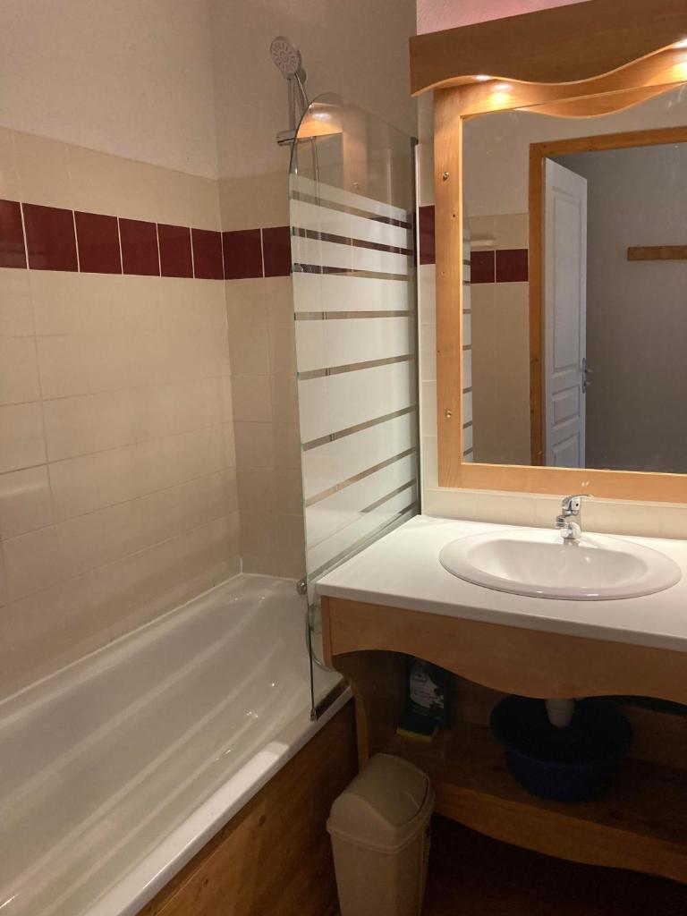 une salle de bain avec un lavabo, une baignoire et un miroir dans l'établissement Appartement pied des pistes, terrasse wifi et parking, à Chamrousse