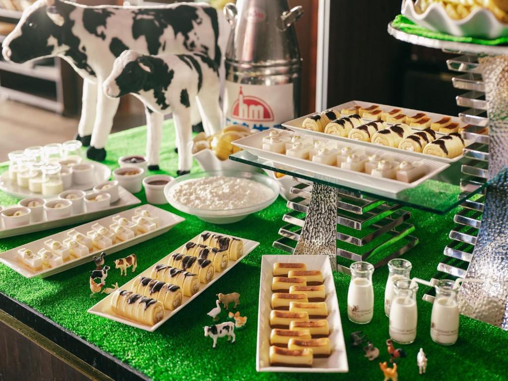 une table avec des pâtisseries et une fausse vache dessus dans l'établissement Hakodate Kokusai Hotel, à Hakodate