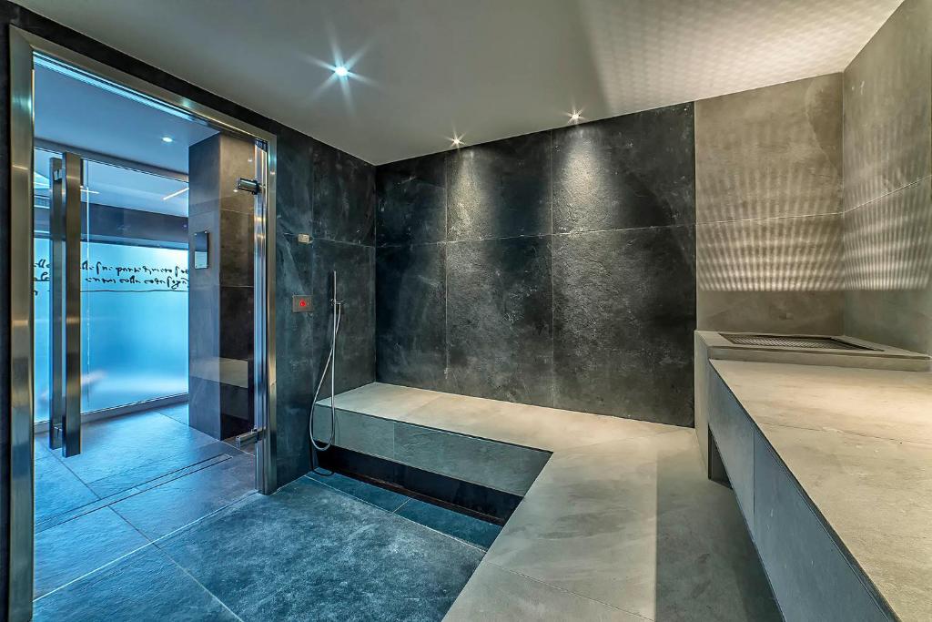 une salle de bain avec une douche à l'italienne et une porte vitrée dans l'établissement Hotel Leonardo Da Vinci Wellness SPA, à Bibione