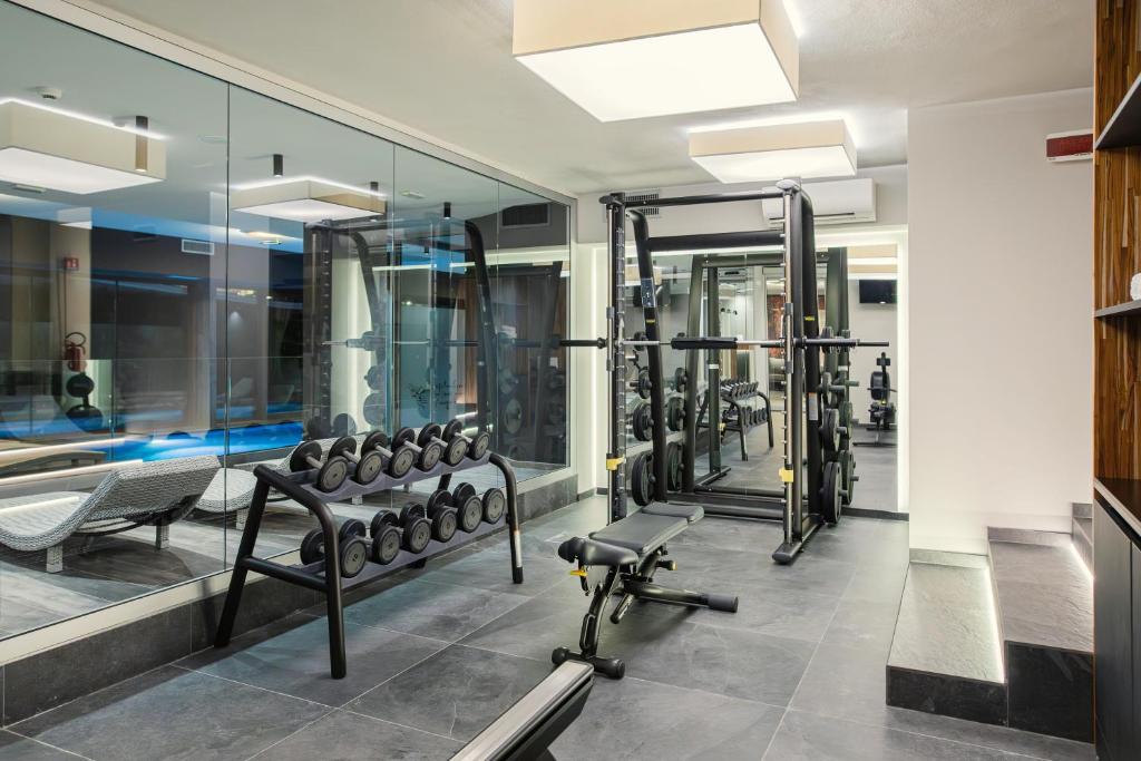 une salle de sport avec une rangée de tapis de course et de machines dans l'établissement Hotel Leonardo Da Vinci Wellness SPA, à Bibione