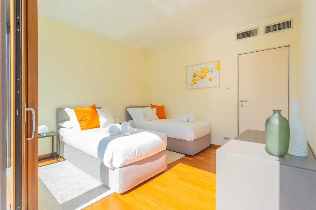 Cette chambre blanche dispose de 2 lits et d'une télévision. dans l'établissement Villa Infinity Lake Como by Rent All Como, à Côme 42 autres photos