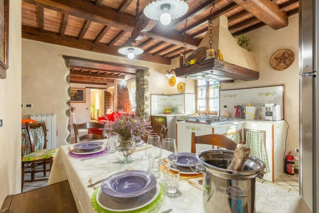 une cuisine avec une table avec des assiettes dessus dans l'établissement Villa Casale Le Selve, à Lucques