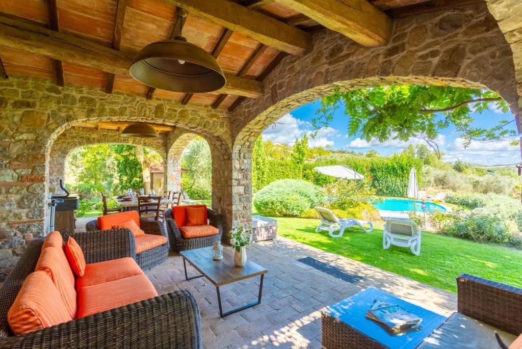 une terrasse meublée et un mur en pierre dans l'établissement Villa Casale Silvia, à Terni