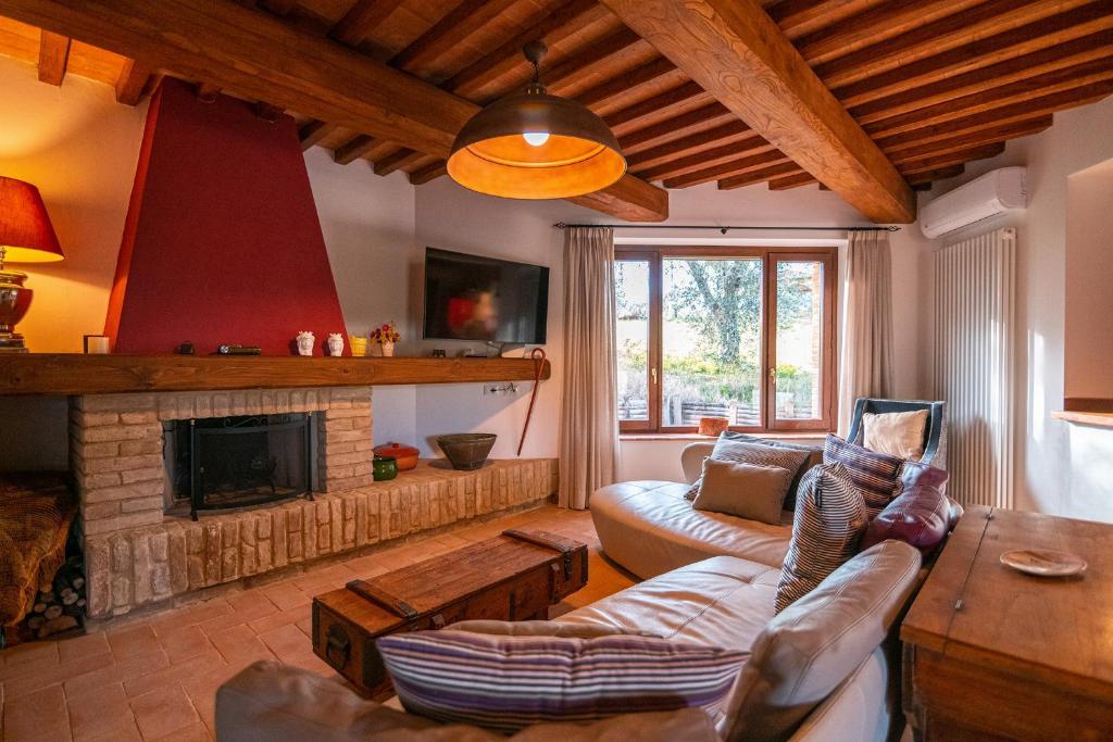 un salon avec un canapé et une cheminée dans l'établissement Villa il Melograno, à Parrano