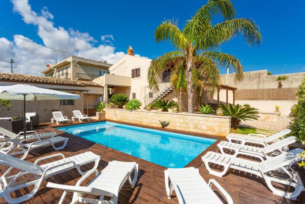 - une piscine avec chaises longues et une villa dans l'établissement Villa Aziz, à Scicli