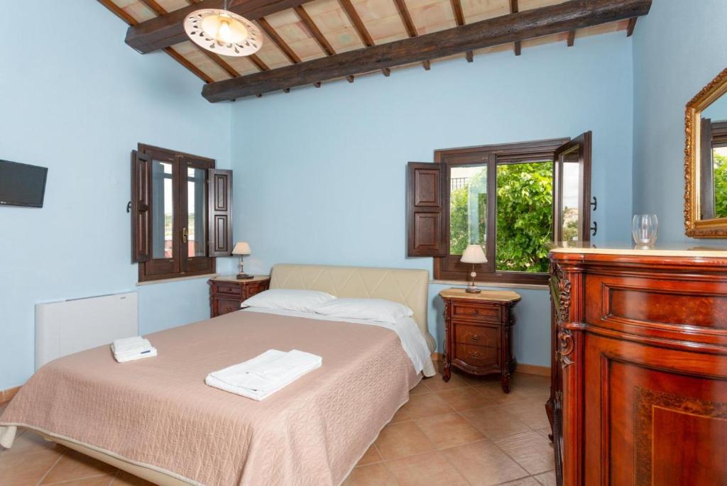 une chambre avec un lit, une commode et un miroir dans l'établissement Villa Aziz, à Scicli