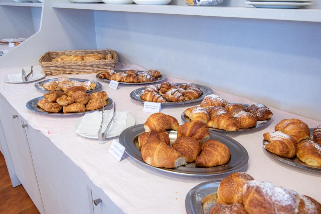 - une table avec des assiettes de croissants et d'autres viennoiseries dans l'établissement Hotel Diamond, à Rimini