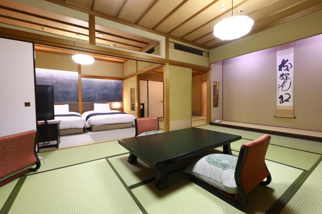 une pièce avec une table et des chaises et une chambre dans l'établissement Oku Yugawara Tsubaki, à Yugawara