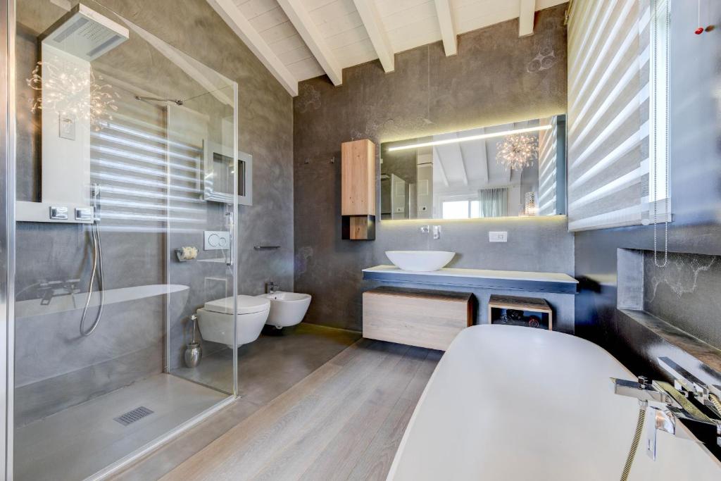 une salle de bain avec un lavabo, une douche et des toilettes dans l'établissement Villa Eden - Borgo degli Olivi, à Sirmione
