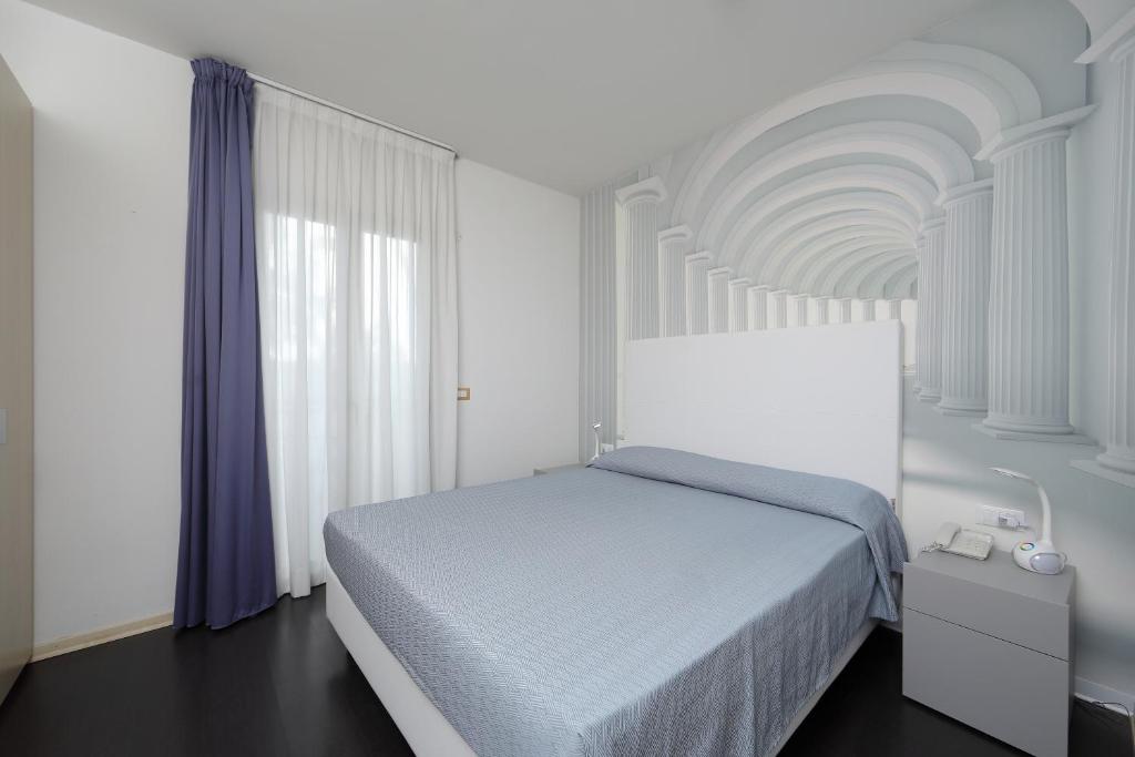- une chambre blanche avec un lit et un plafond blanc dans l'établissement Hotel Anapaya, à Lignano Sabbiadoro