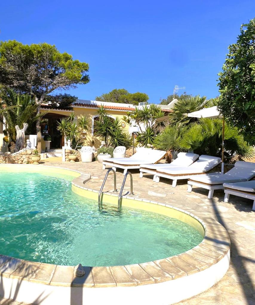 une piscine avec des chaises, une table et de l'eau dans l'établissement Luagos club Resort, à Lampedusa