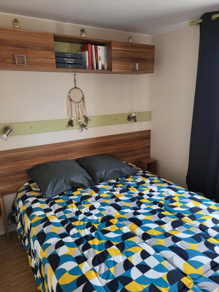 une chambre avec un lit avec une couette colorée dans l'établissement Anthony MH 140, à Port-la-Nouvelle 2 autres photos