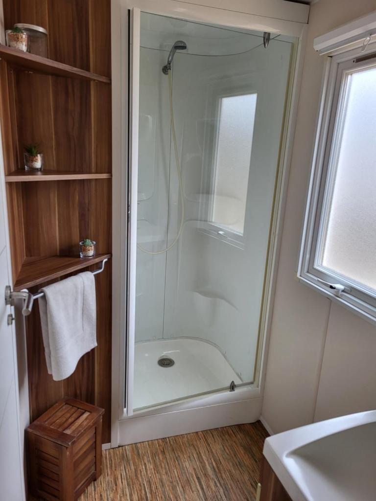 une douche avec une porte vitrée dans une salle de bain dans l'établissement Anthony MH 140, à Port-la-Nouvelle