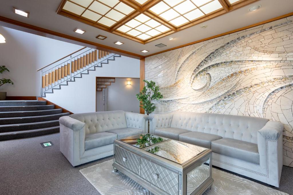 un hall d'entrée avec un canapé et une peinture murale dans l'établissement Hakone Ashinoko Bikeikan 箱根芦ノ湖 美景館, à Hakone