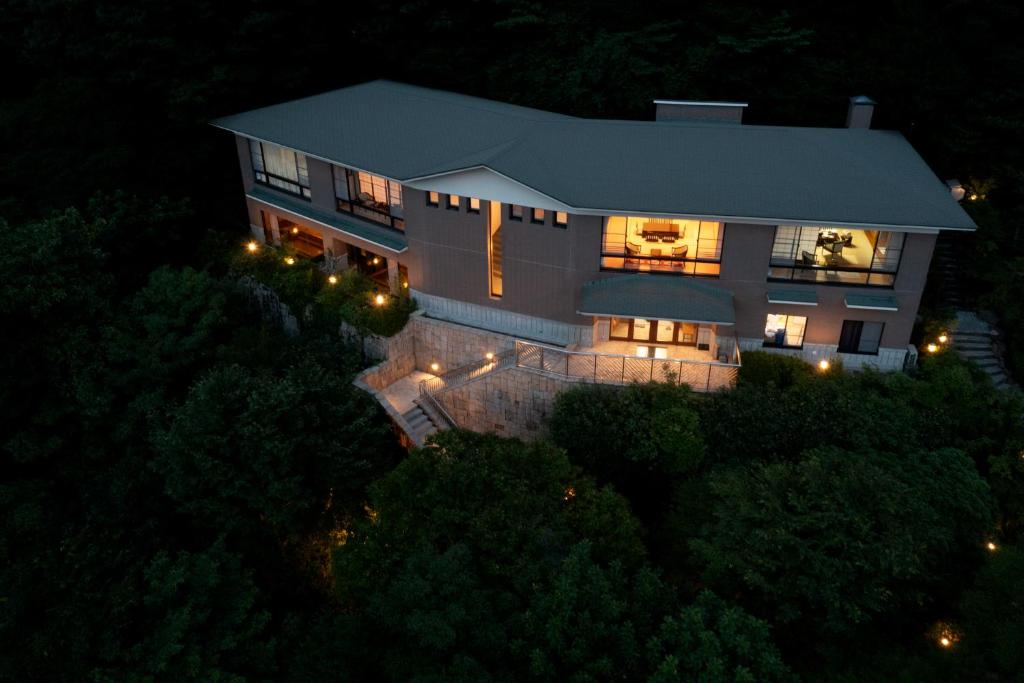 - une vue aérienne sur une maison la nuit dans l'établissement Hakone Ashinoko Bikeikan 箱根芦ノ湖 美景館, à Hakone