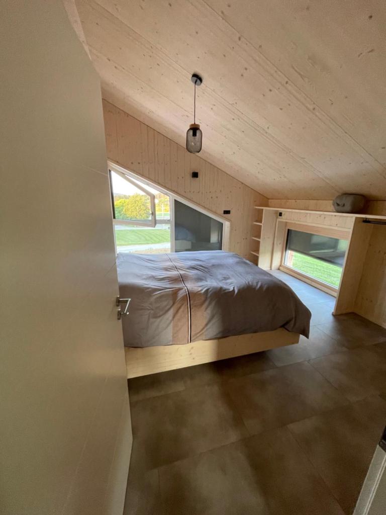 un lit dans une petite pièce avec une fenêtre dans l'établissement Magnifique villa nature le Bois d'Aura, à Luisans 37 autres photos