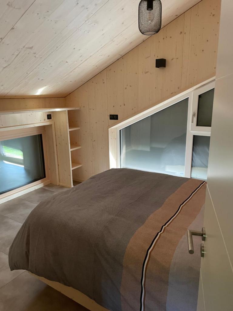 - une chambre dans une maison avec un grand lit dans l'établissement Magnifique villa nature le Bois d'Aura, à Luisans