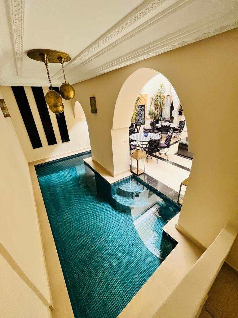 - un couloir avec une piscine dans une maison dans l'établissement Riad Oasissime, à Marrakech