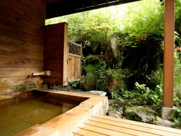 une douche extérieure avec un banc dans un jardin dans l'établissement Ryokan Kutsuroginoya Yuu, à Takayama