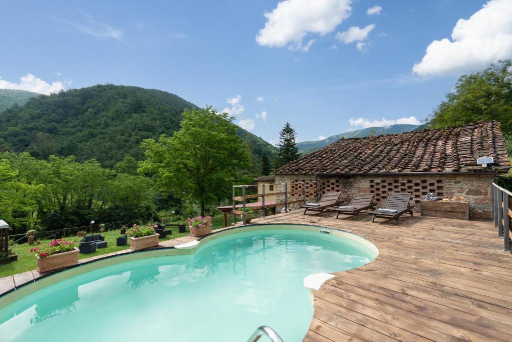 une piscine avec une terrasse en bois et une maison dans l'établissement Locanda Di Alberi, à Borgo San Lorenzo