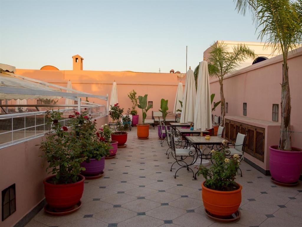 un patio avec des tables, des chaises et des plantes en pot dans l'établissement Riad Magda & Spa, à Marrakech 8 autres photos