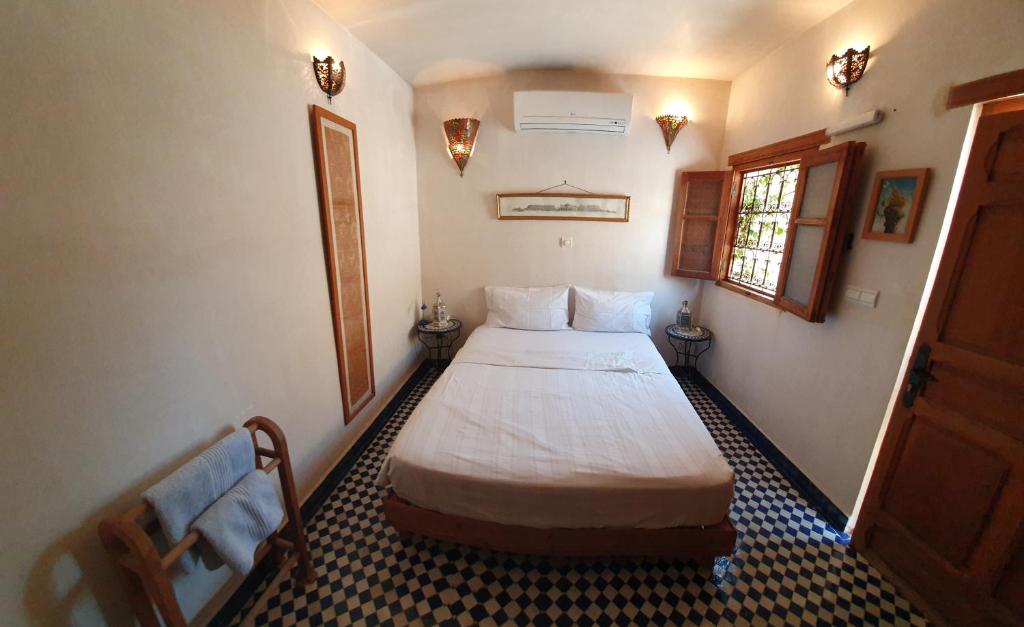 une chambre avec un grand lit dans une pièce dans l'établissement Dar Houdou, à Fès