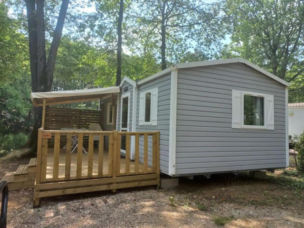 une petite maison avec un porche et une terrasse dans l'établissement Mobil-House 2 chambres Saint-Chéron, à Saint-Chéron