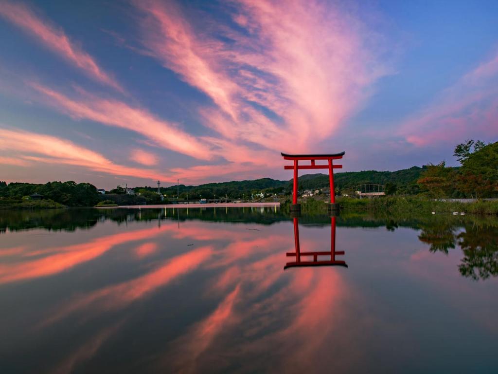 une porte rouge au milieu d'un lac dans l'établissement Kameyama Onsen Hotel, à Kimitsu