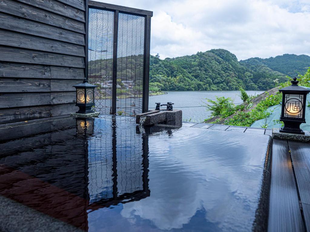 une maison avec deux lumières au bord d'un plan d'eau dans l'établissement Kameyama Onsen Hotel, à Kimitsu