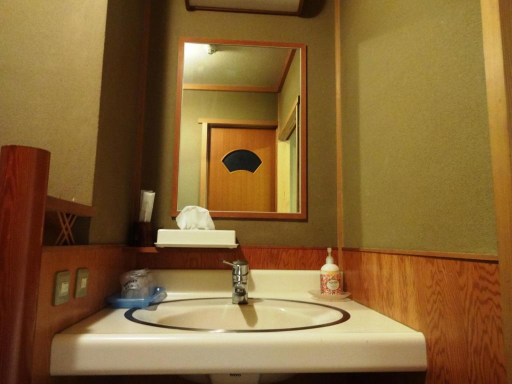 une salle de bain avec un lavabo et un miroir dans l'établissement Yamatoya, à Toyooka 21 autres photos
