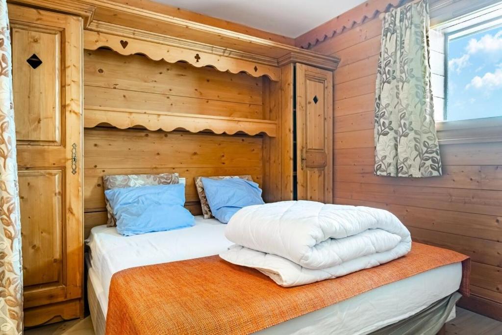 - une chambre avec un lit et un mur en bois dans l'établissement Residence Les Hauts Bois - maeva Home, à Aime La Plagne
