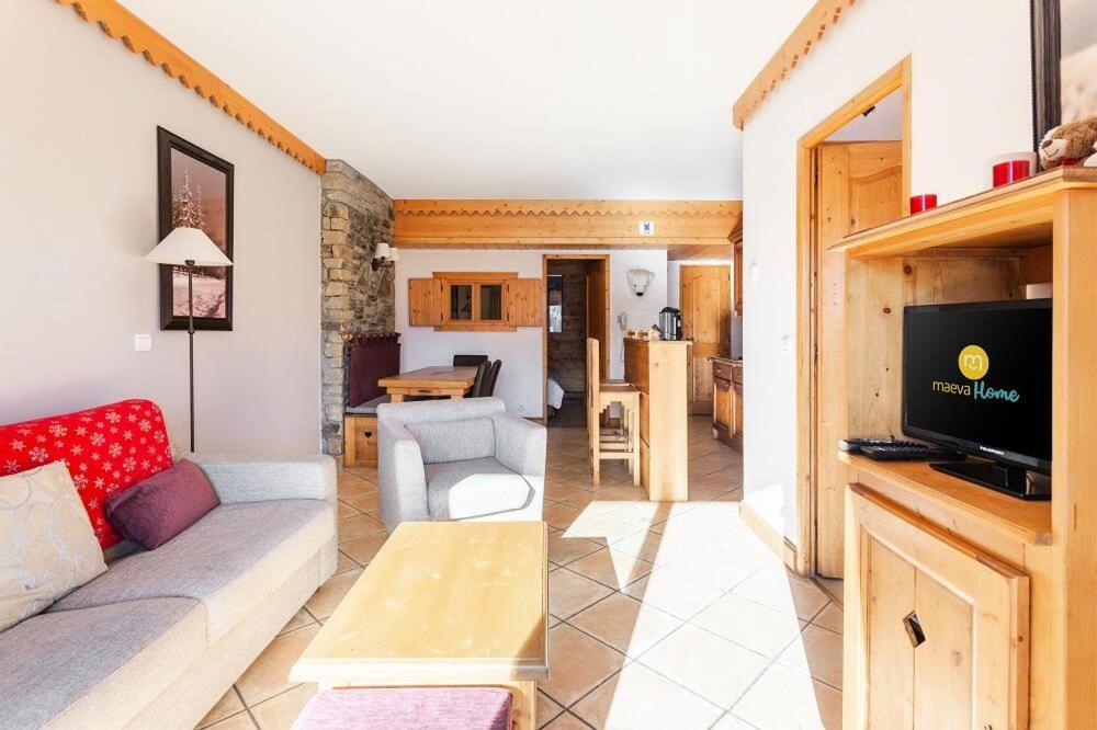 - un salon avec un canapé et une télévision dans l'établissement Residence Les Hauts Bois - maeva Home, à Aime La Plagne