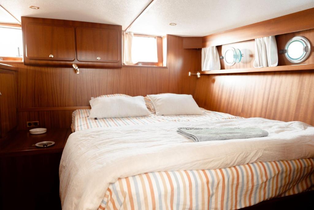 - une chambre avec un grand lit dans un bateau dans l'établissement Hébergement insolite en demi-pension et excursion gastronomique en bateau, à Bouzigues