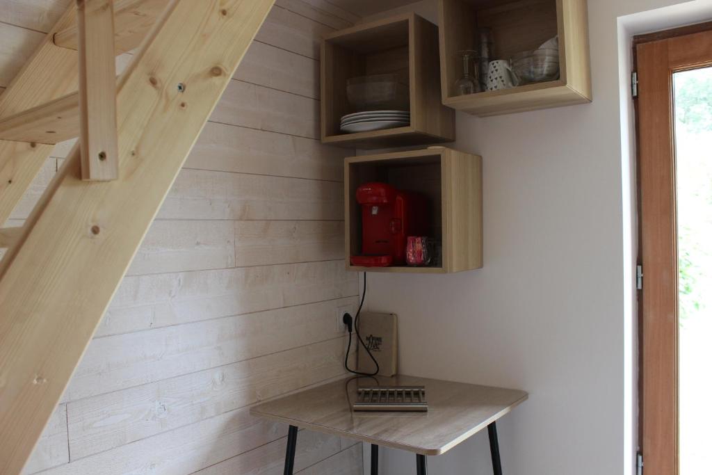 Cette chambre est dotée d'un mur en bois avec une table et un escalier. dans l'établissement Le Biaou, à Albias