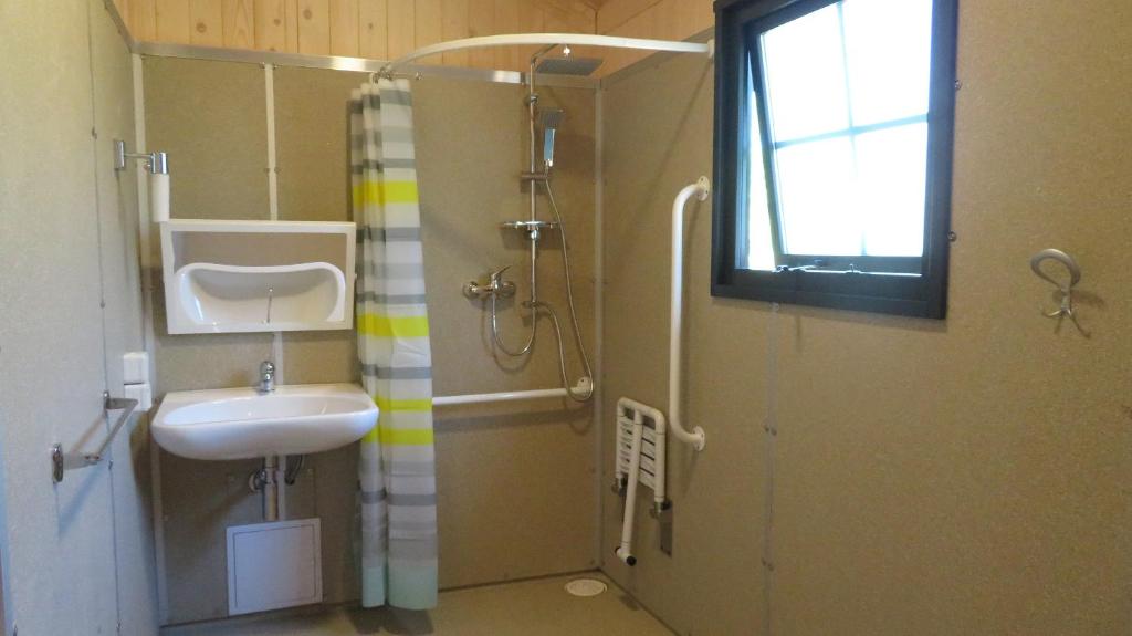 une petite salle de bain avec un lavabo et une douche dans l'établissement Lodges du Ushuaïa Villages Camping les 4 Saisons, à Grane 37 autres photos