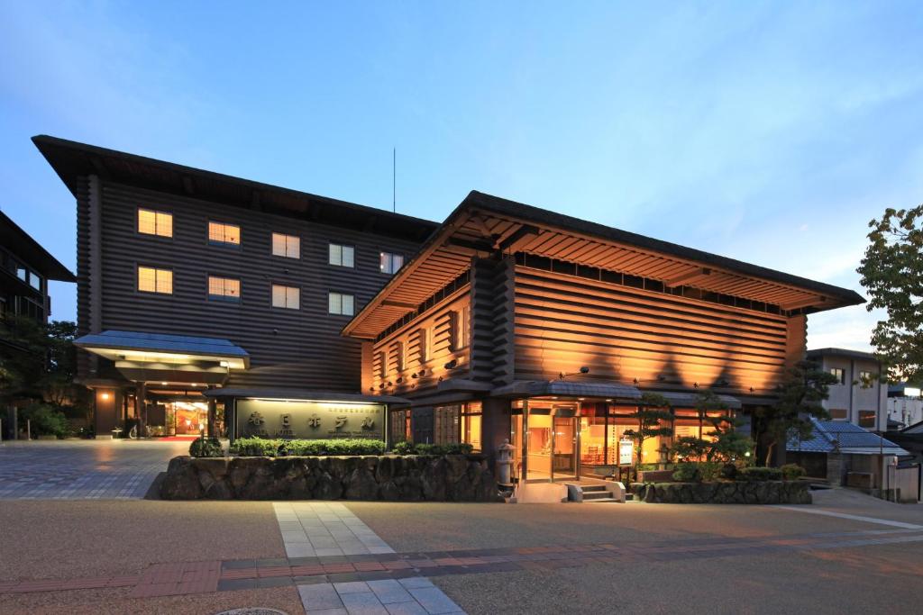 un bâtiment avec un toit en gambrel dans une rue dans l'établissement Kasuga Hotel, à Nara