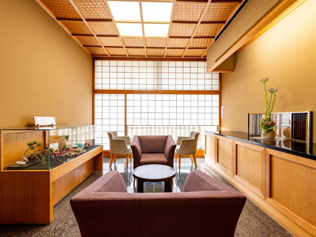 une salle d'attente avec des chaises et une table dans l'établissement Awara Onsen Matuya Sen Sen, à Awara