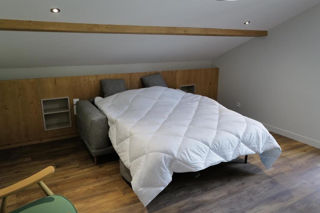 une chambre avec un lit blanc et un canapé dans l'établissement Les Gîtes d'Aillon et d'Ailleurs, à Aillon-le-Jeune