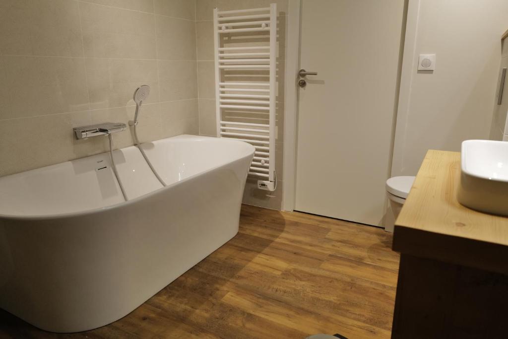 une salle de bain avec une baignoire blanche et un lavabo dans l'établissement Les Gîtes d'Aillon et d'Ailleurs, à Aillon-le-Jeune 36 autres photos