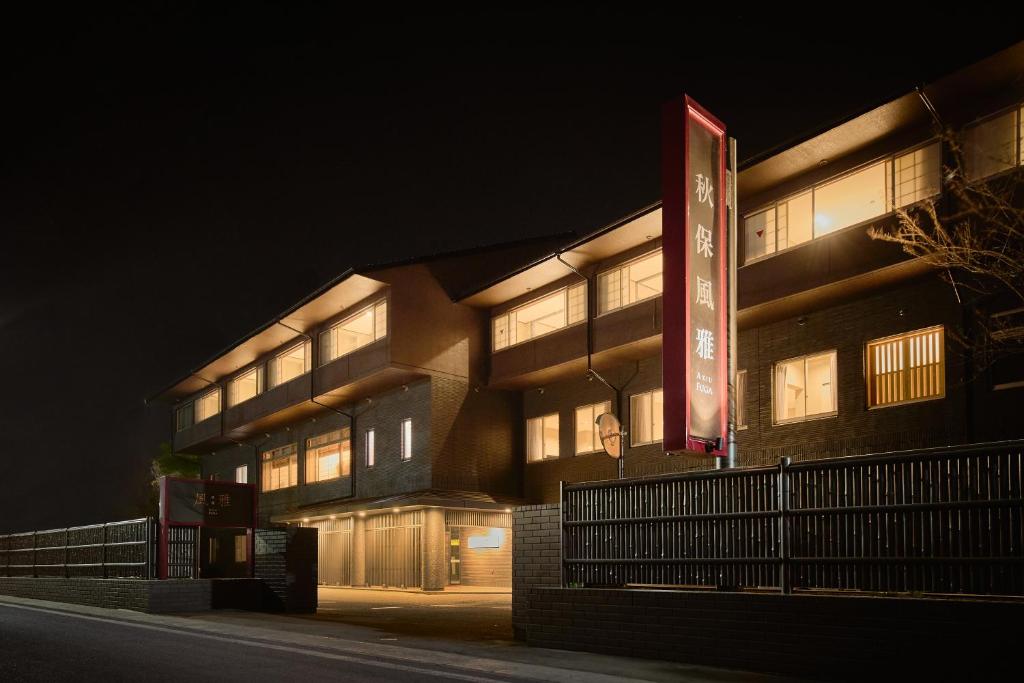 un bâtiment avec un panneau devant lui la nuit dans l'établissement Akiu Fuga, à Sendai