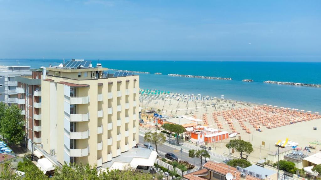 - une vue sur la plage et un bâtiment dans l'établissement Hotel Colorado Cesenatico, à Cesenatico