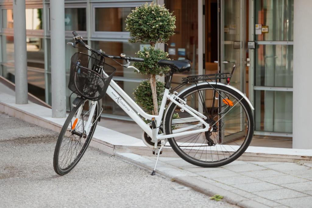 un vélo garé sur un trottoir devant un bâtiment dans l'établissement Hotel Rosanna 3 Stelle Superior, à Lido di Jesolo