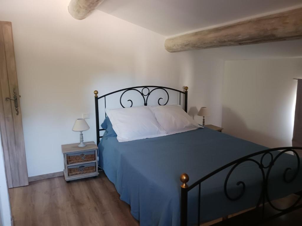 une chambre avec un lit avec une couette bleue dans l'établissement Mas de la Chêneraie Blanche, Maison de vacances avec piscine en Luberon, à Roussillon