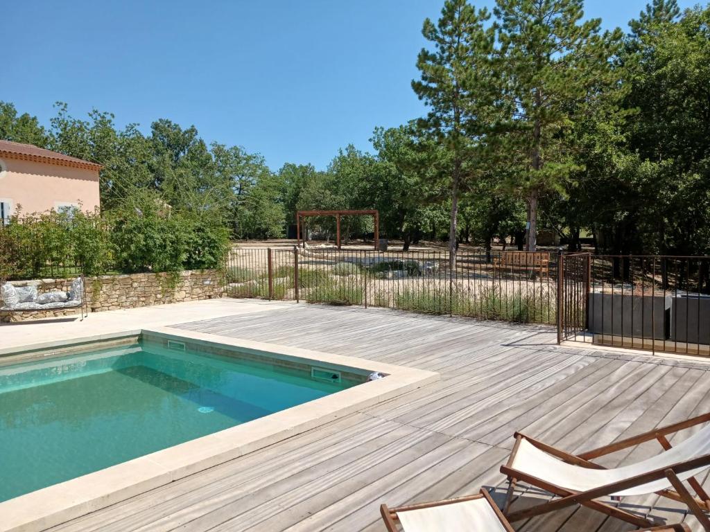 - une piscine avec 2 chaises et un panier de basket dans l'établissement Mas de la Chêneraie Blanche, Maison de vacances avec piscine en Luberon, à Roussillon