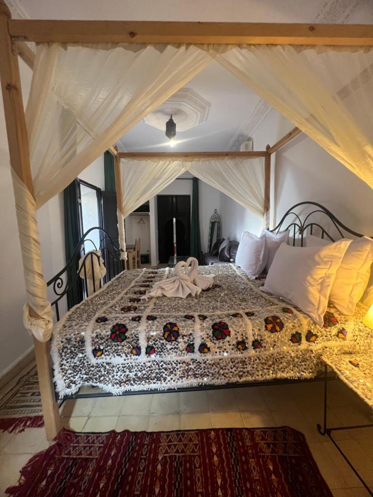 une chambre avec un grand lit à baldaquin dans l'établissement Riad Ago, à Marrakech