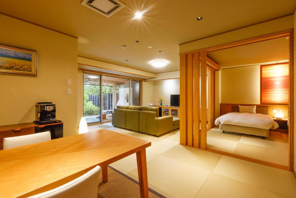 une chambre avec une table à manger et une chambre dans l'établissement Kaikatei Hanagozen, à Kyōtango