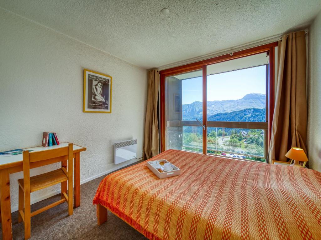 une chambre avec un lit, un bureau et une fenêtre dans l'établissement Apartment Pegase Phenix-39 by Interhome, au Corbier