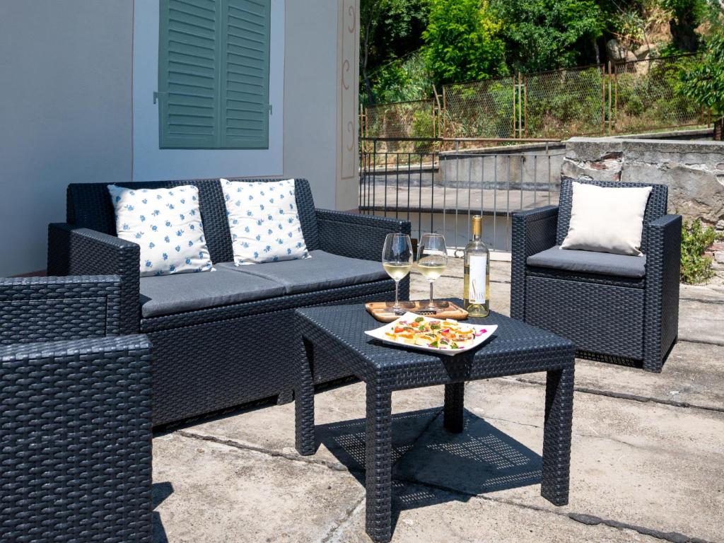 un patio avec un canapé et une table avec une assiette de nourriture dans l'établissement Villa Savio by Interhome, à La Morra