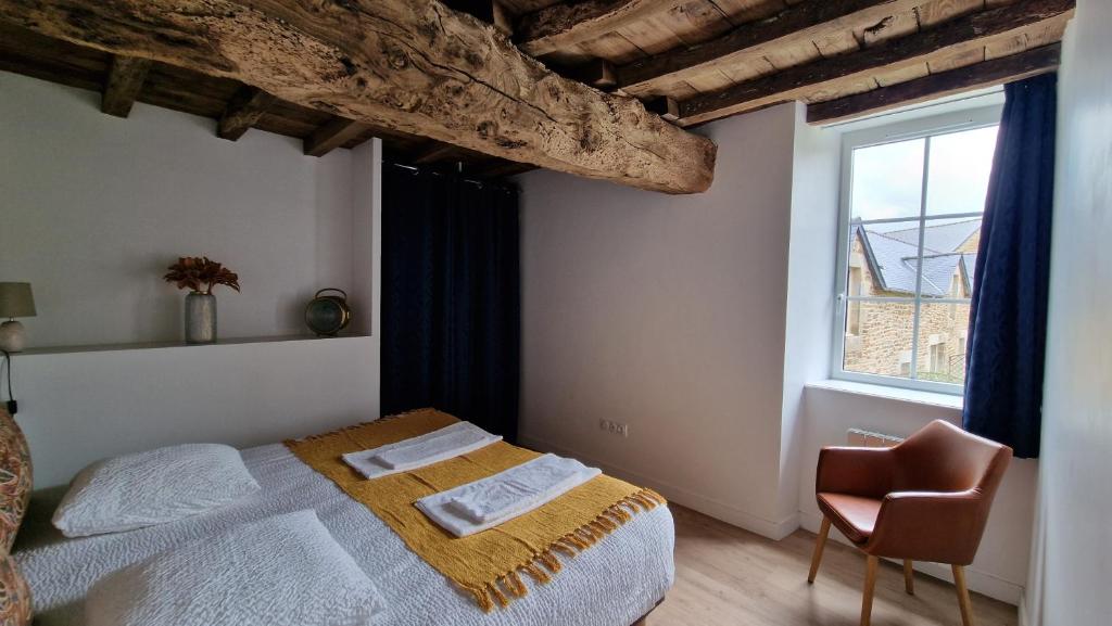 une chambre avec un lit, une chaise et une fenêtre dans l'établissement Les gîtes du Haut Pin, à Calorguen 37 autres photos