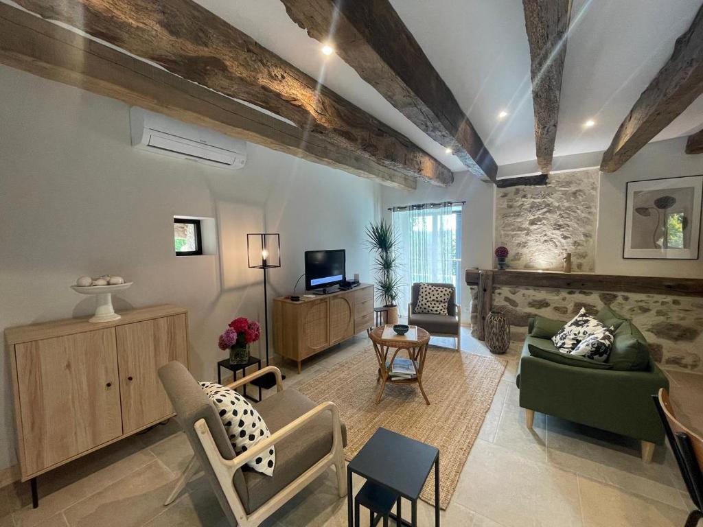 un salon avec un canapé et une télévision dans l'établissement La Maison d'Emile- le Gîte- La Clef de la Grange, à La Fouillade